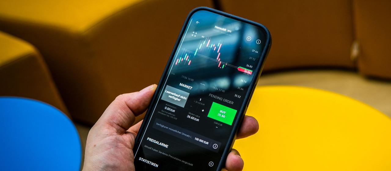 Eine Person handelt Aktien auf einem Smartphone.