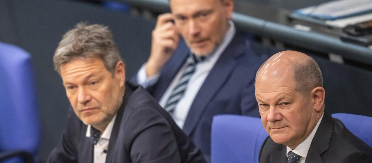 Olaf Scholz (r), verfolgt neben Robert Habeck (l) und Christian Lindner die Debatte zur Haushaltslage im Bundestag. 