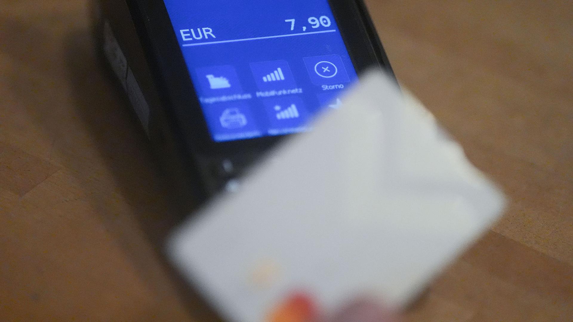 Ein Mann h�lt seine Debitkarte an ein Leseger�t an der Kasse. | Marcus Brandt/dpa