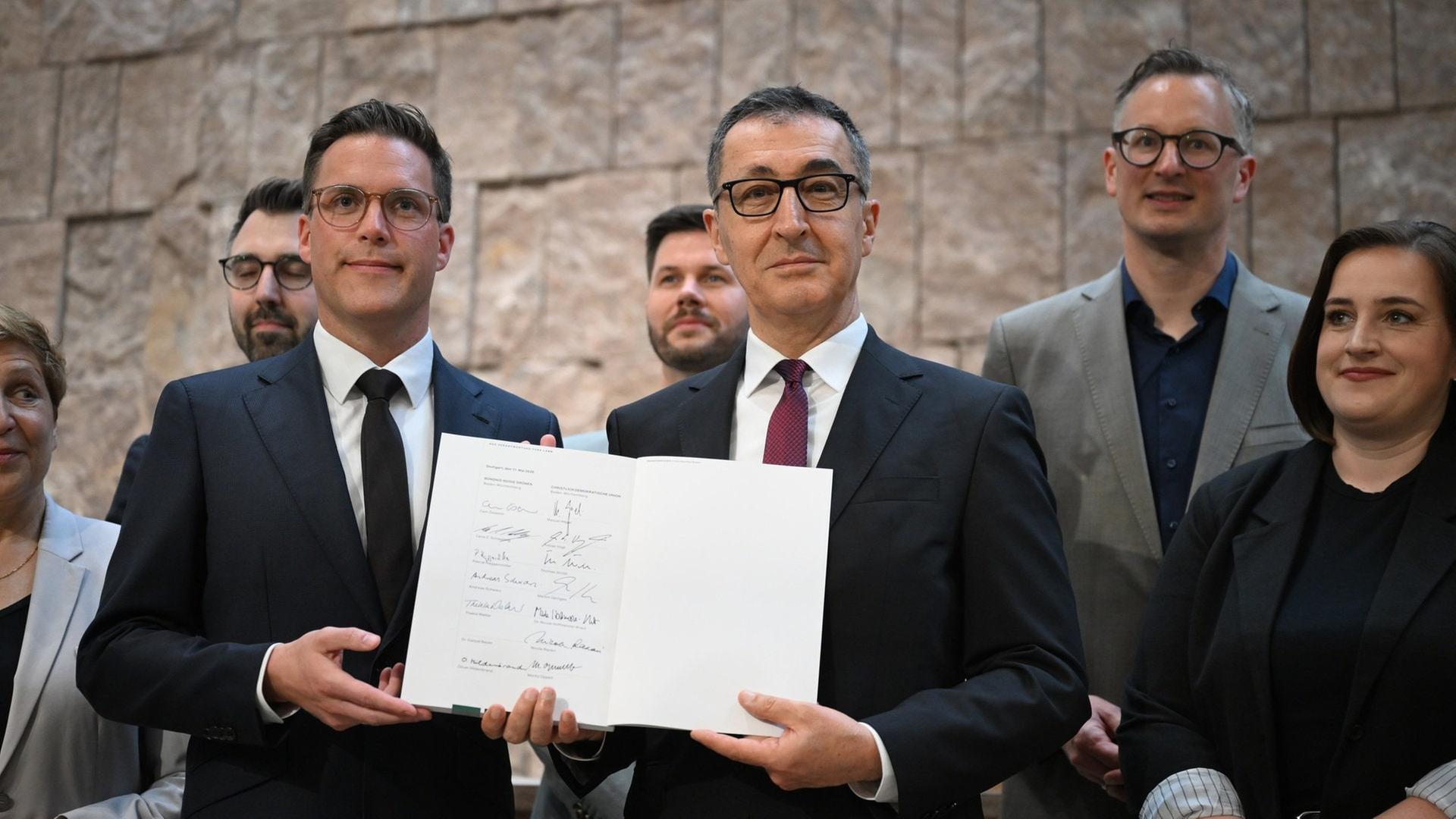 Manuel Hagel (CDU,l) und der designierte Ministerpräsident Cem Özdemir (Bündnis 90 / Die Grünen) unterzeichnen den Koalitionsvertrag zur Bildung einer Landesregierung in Baden-Württemberg.  | dpa Bildfunk, picture alliance/dpa | Bernd Weißbrod