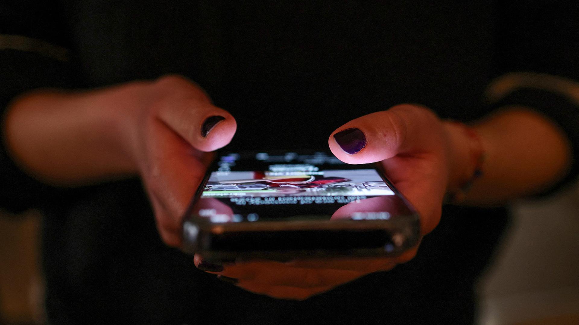 Ein Mädchen checkt Socialmedia-Posts auf ihren Handy. | REUTERS