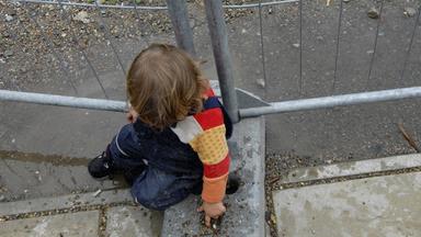 Ein Kind sitzt auf dem Boden