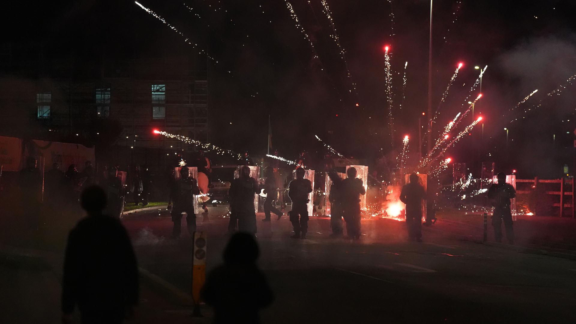Demonstranten werfen bei Ausschreitungen im irischen Saggard Feuerwerkskörper auf Beamte der Polizei | dpa