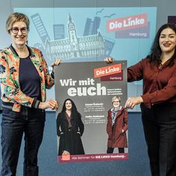 Heike Sudmann (l.) und Cansu Özdemir, Spitzenkandidatinnen der Partei Die Linke, präsentieren die Plakat-Kampagne der Linken zur Bürgerschaftswahl in Hamburg.