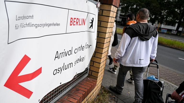 Asylsuchende verlassen eine Registrierungsstelle in Berlin.