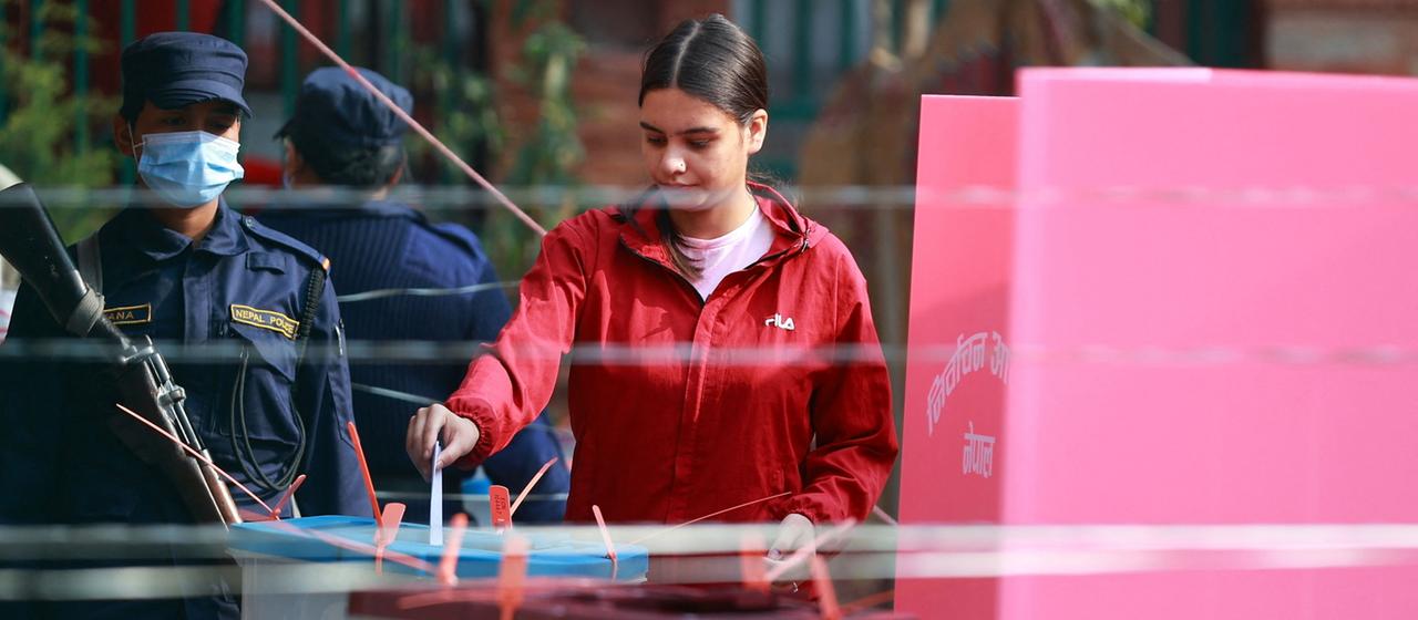 Eine Frau wirft ihren Wahlschein in eine Wahlurne in Kathmandu, Nepal.