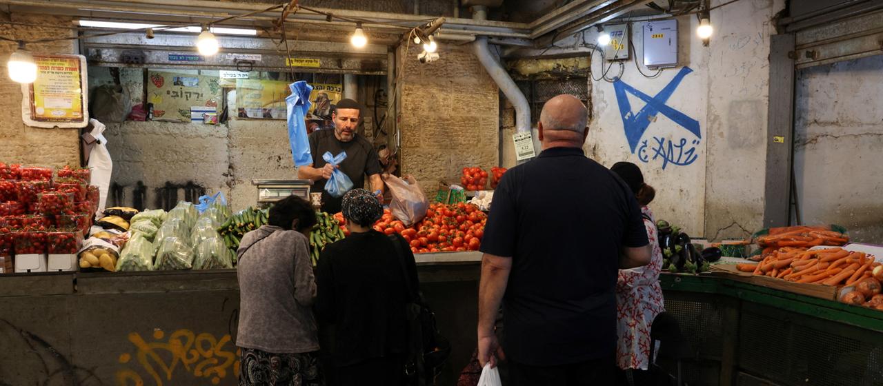 Ein Mann bedient Kunden an einem Gemüsestand auf dem Machane-Yehuda-Markt in Jerusalem.