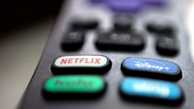 Logos von Netflix und Disney auf einer TV-Fernbedienung
