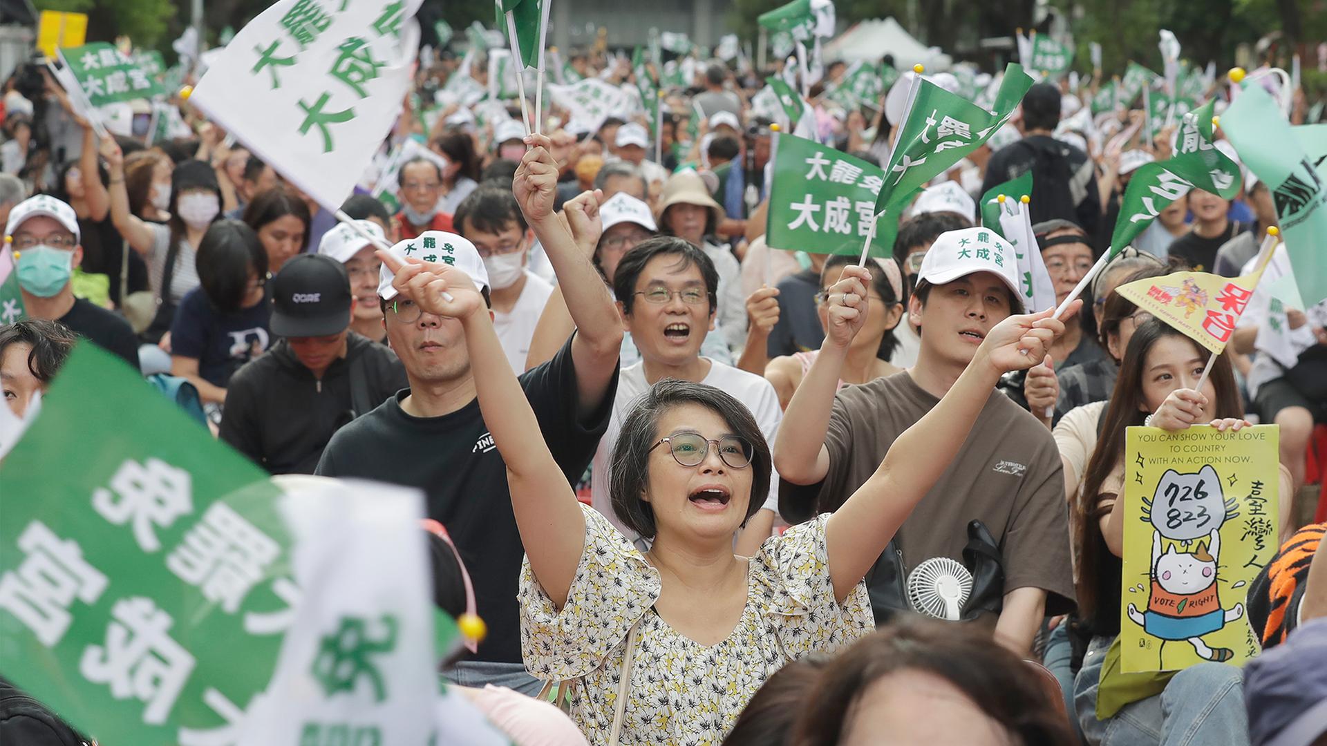 Menschen reagieren auf die Auszählung der Stimmen nach einer Abstimmung in Taipeh. | dpa