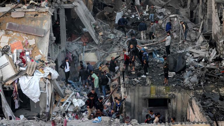 Palästinenser stehen in den Trümmern zerstörter Gebäude in Rafah im Gazastreifen