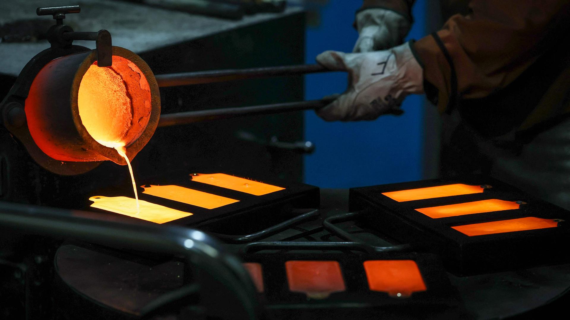 Ein Raffineriearbeiter gießt flüssiges Gold aus einem Ofen in Gussformen im australischen Sydney.  | AFP