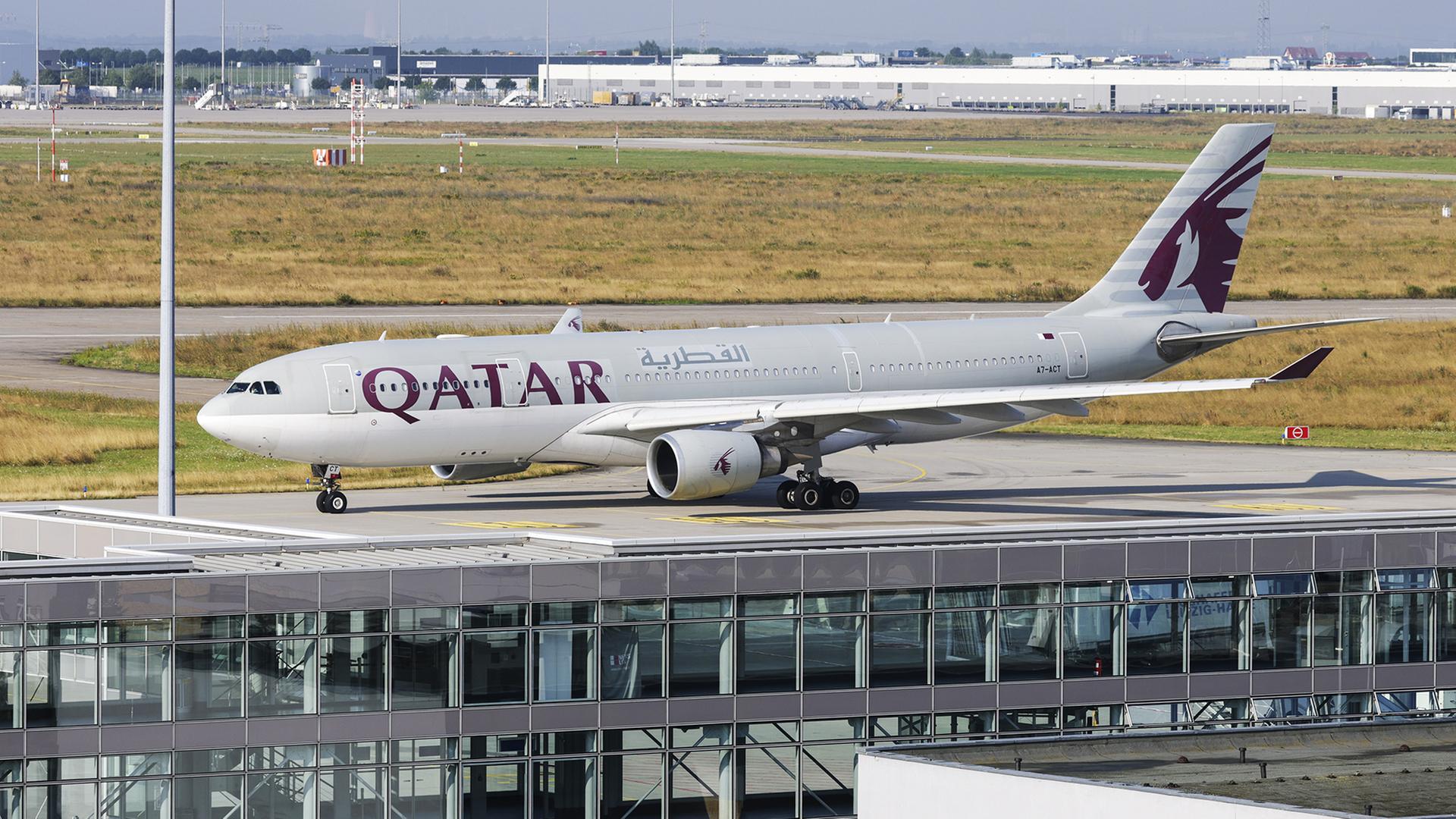 Ein Qatar Airways Flugzeug rollt auf einer Landebahn vor einem Flughafenterminal. (Archivbild: 18.7.2025) | dpa