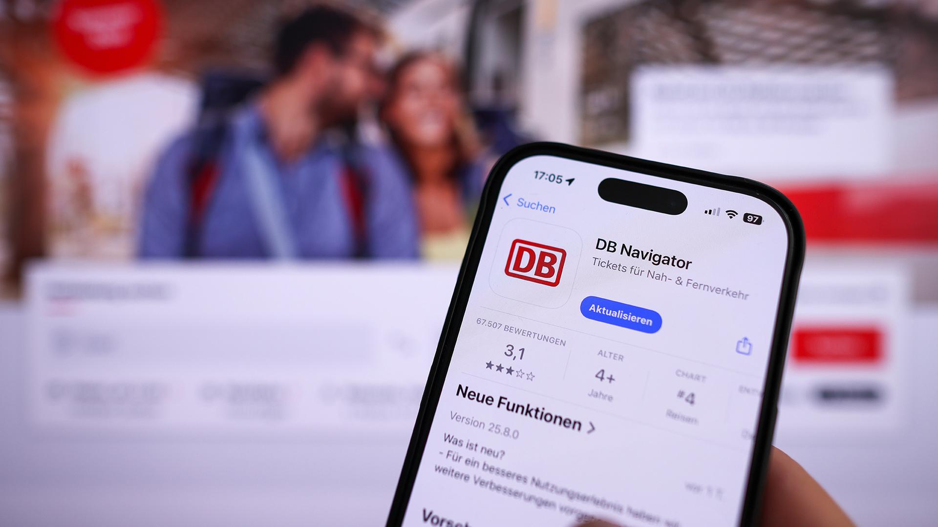 Eine Hand hält ein Mobiltelefon mit der App DB-Navigator im App-Store. | dpa