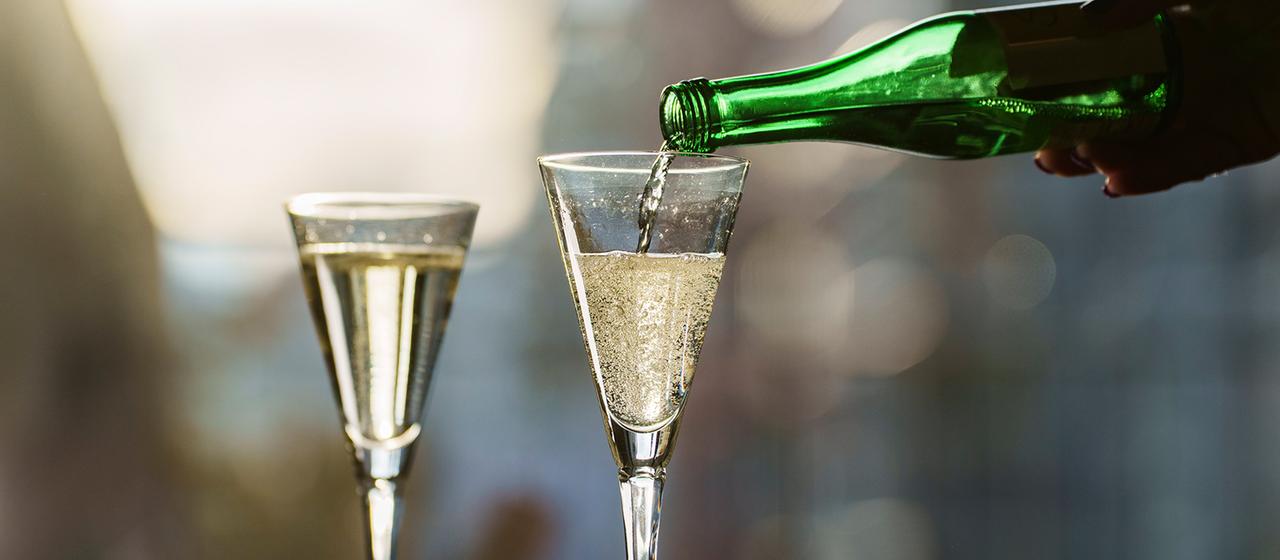 Ein Piccolo-Sekt wird in ein Sektglas gegossen.