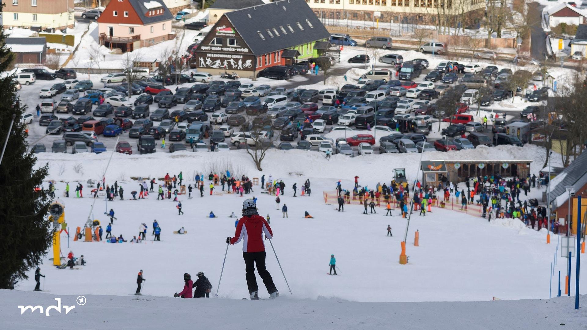 Wintersportfans sind auf dem Skihang unterwegs | picture alliance/dpa | Matthias Rietschel Wintersportfans sind auf dem Skihang unterwegs