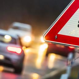 Verkehrsschild Vorsicht Straßenglätte an einer befahrenen Straße (Symbolbild Glatteis) 