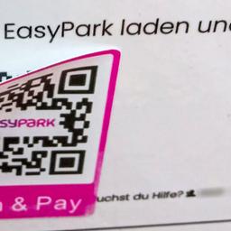 Auf einem Parkautomaten ist ein betrügerischer QR-Code über dem Original geklebt