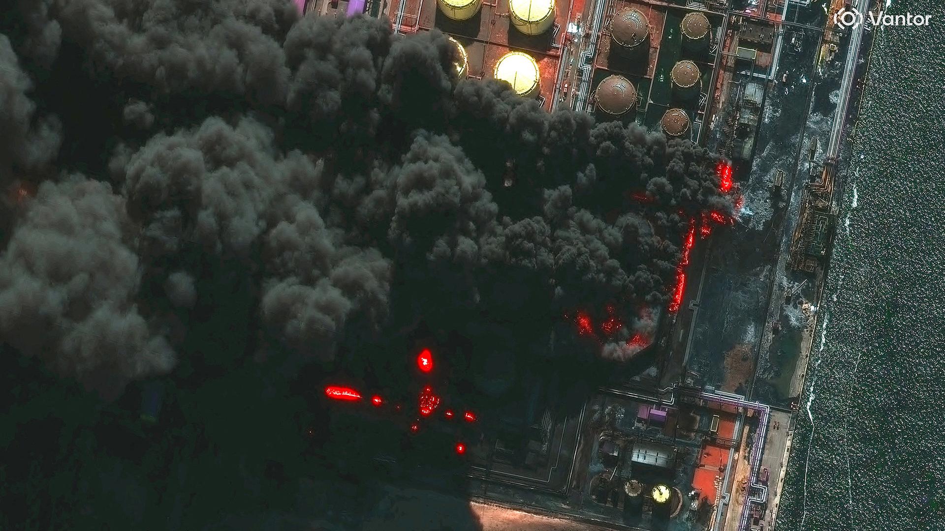 Eine Satellitenaufnahme zeigt eine brennende Industrieanlage. (Archivbild: 27.3.2026) | Vantor/Handout via REUTERS
