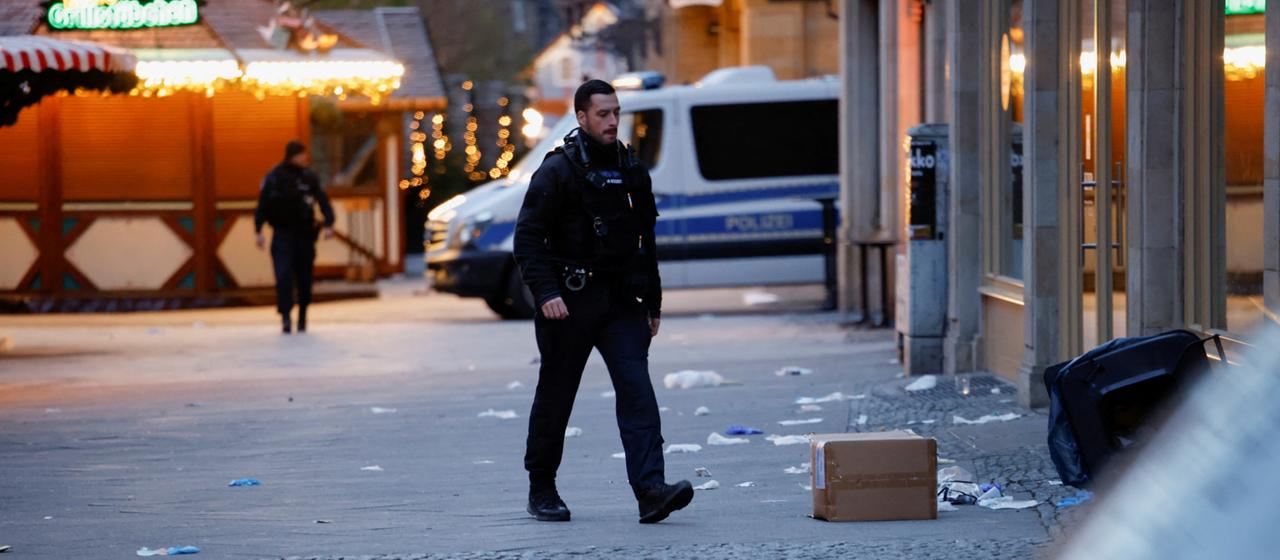 Ein Polizist läuft über den abgesperrten Weihnachtsmarkt in Magdeburg