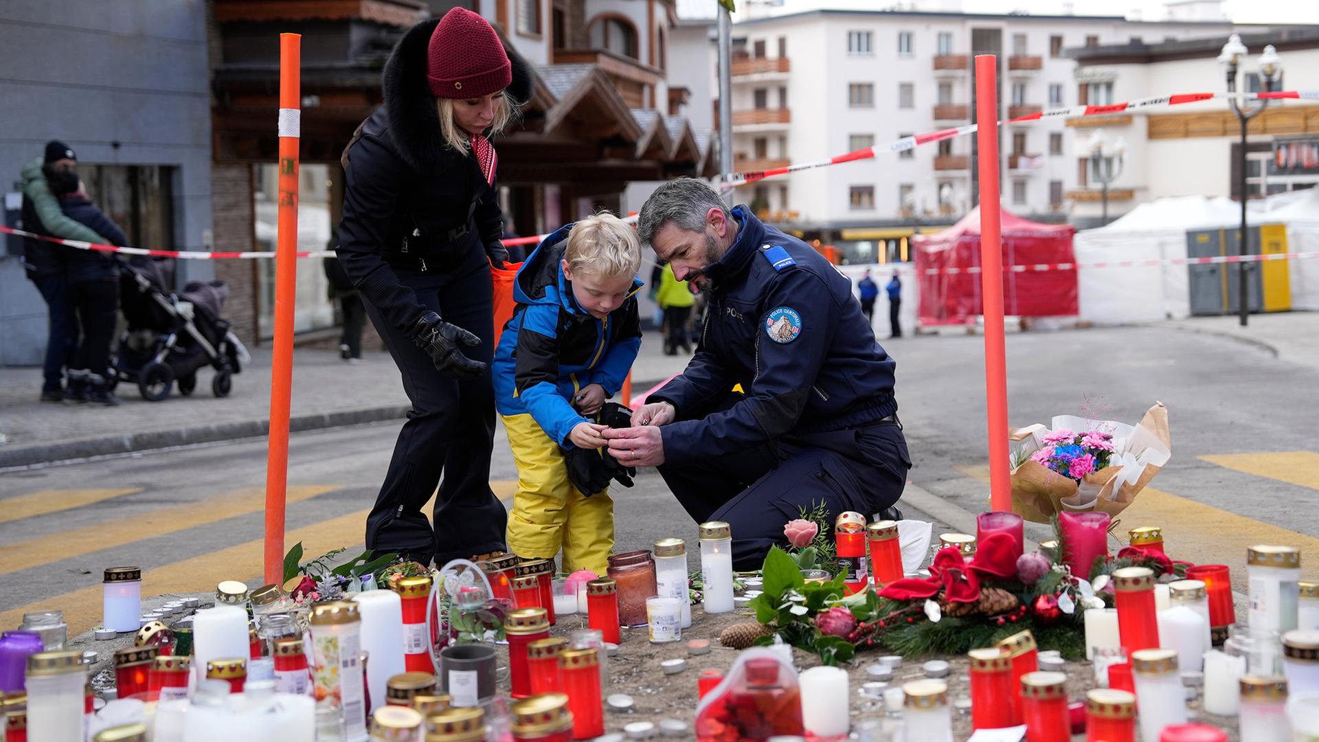 Ein Polizist hilft einem Jungen beim Anz�nden einer Kerze in der N�he der Bar 