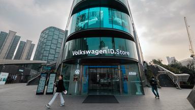 Passanten gehen vor einem Volkswagen Store in Shanghai vorbei.