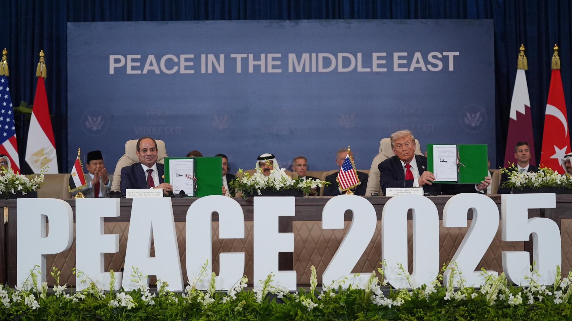 Donald Trump und Abdel Fattah al-Sisi zeigen in Scharm el Scheich ein Dokument | AP