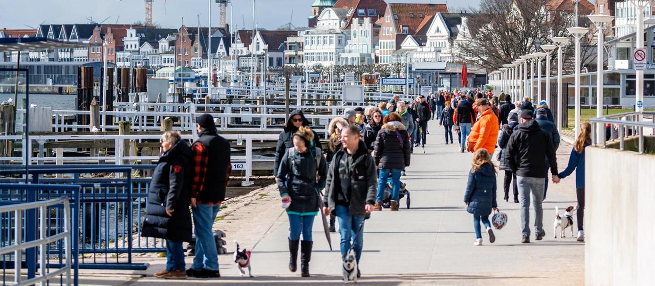 Touristen auf der Promenade von Travemünde.