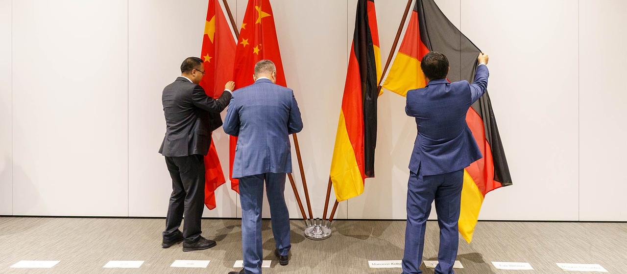 Chinesische und deutsche Nationalflaggen werden für einen Fototermin vorbereitet.