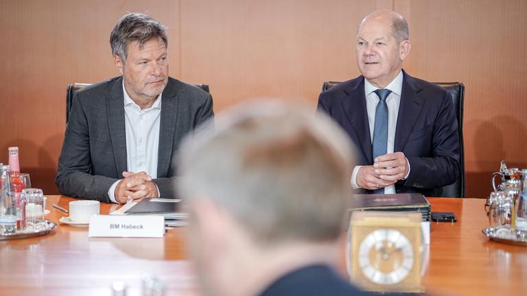 Bundeskanzler Olaf Scholz (r, SPD) und Robert Habeck (Bündnis 90/Die Grünen), Bundesminister für Wirtschaft und Klimaschutz, nehmen an der Sitzung des Bundeskabinetts im Bundeskanzleramt hinter Christian Lindner (FDP), Bundesminister der Finanzen, teil (Archivbild). 