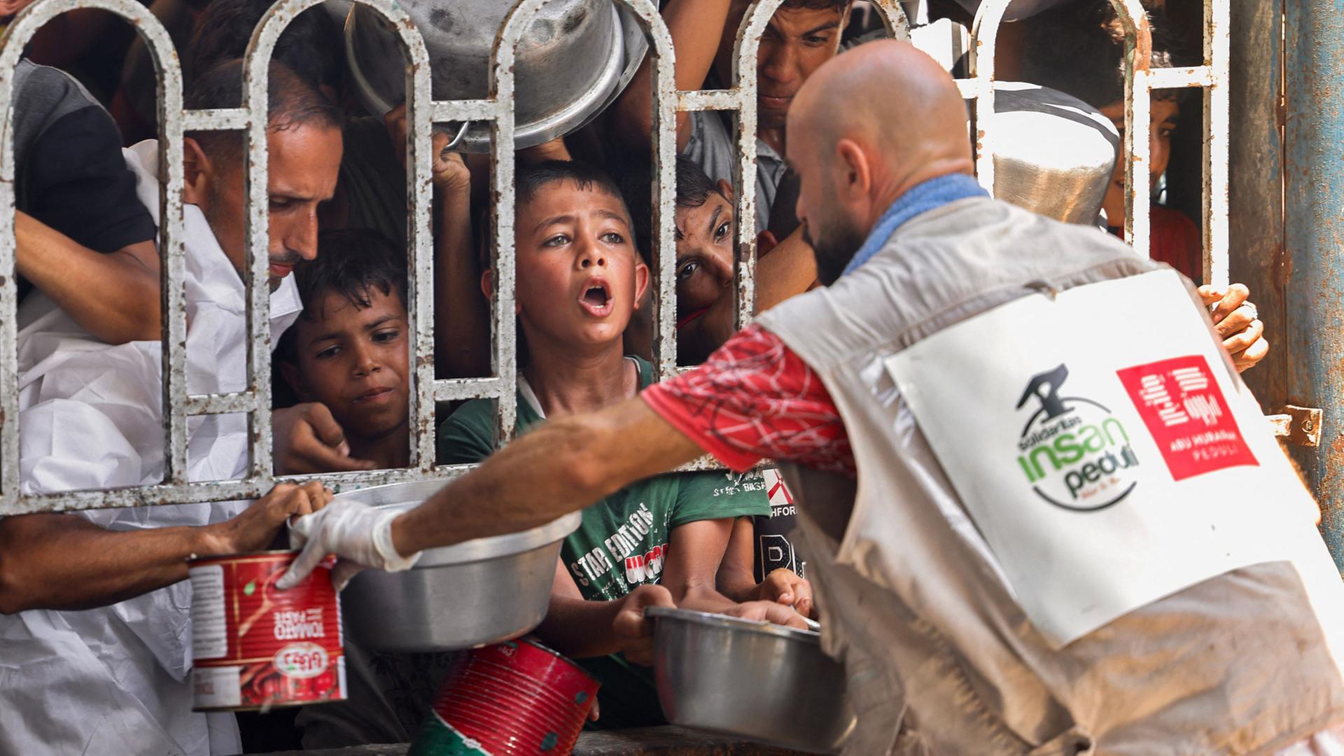Hilfskräfte geben Essen im Mawasi-Gebiet in Chan Yunis, Gazastreifen aus. | AFP
