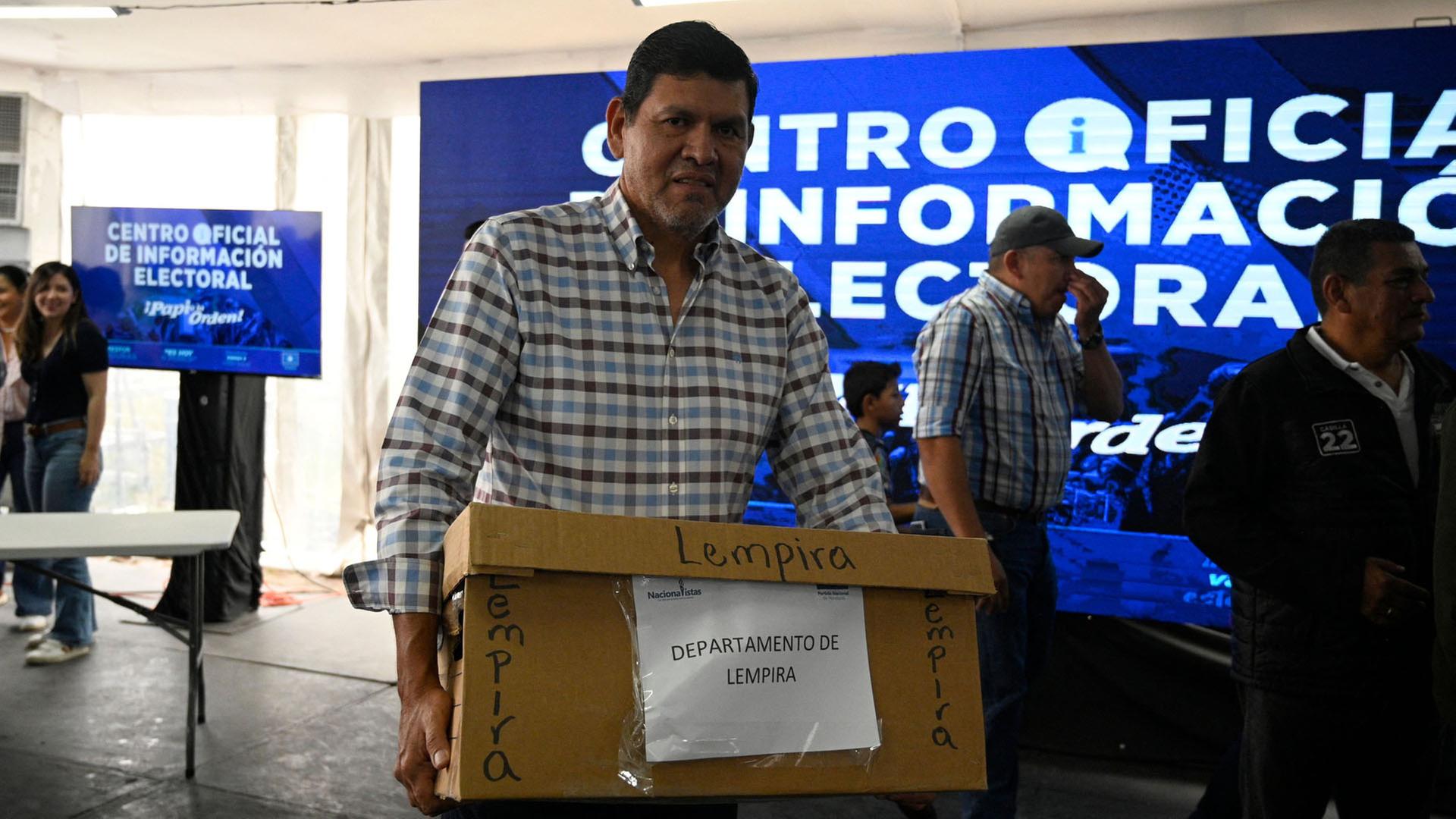 Ein Mann trägt eine Kiste mit Wahlzetteln zur Präsidentschaftswahl in Honduras. | AFP