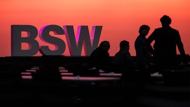 Das BSW Logo auf der Bühne des abgedunkelten Halle des Parteitages