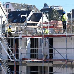 Auf einer Baustelle für Wohnungen und Sozialwohnungen arbeiten Bauarbeiter am Rohbau.