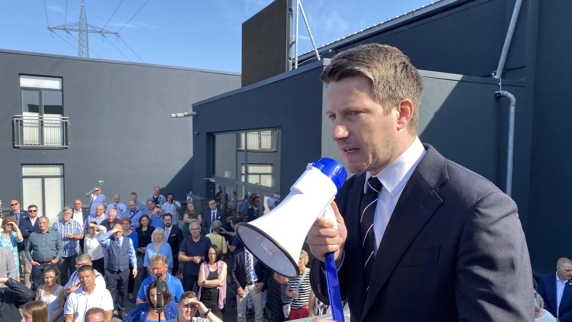 Martin Vincentz, AfD, spricht beim Parteitag in Marl in ein Megafon | WDR