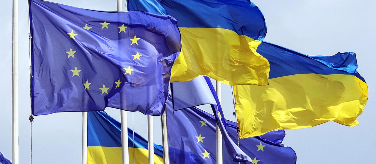 Flaggen der Ukraine und EU wehen nebeneinander im Wind