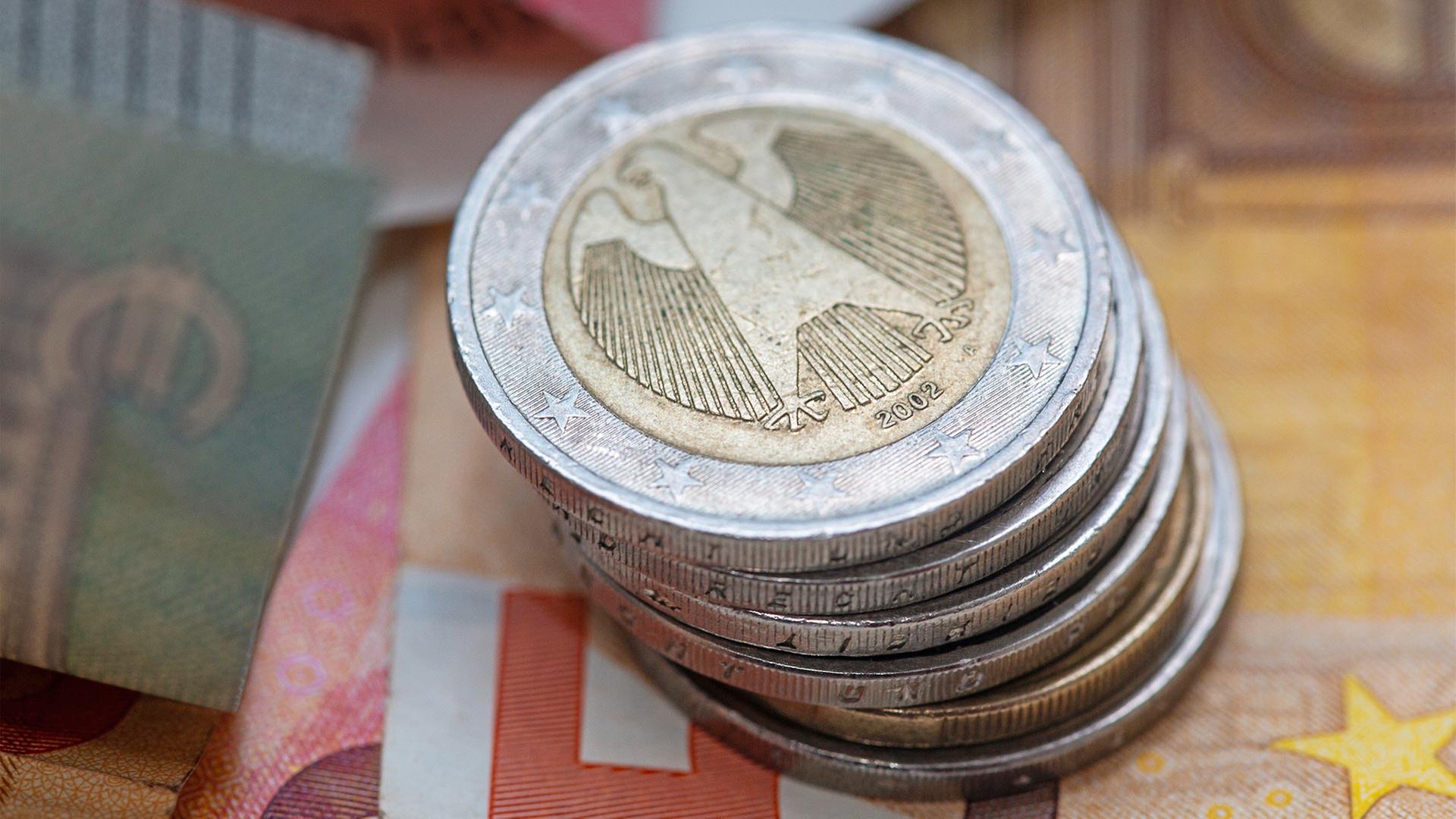 Ein Stapel Zwei-Euro-MÃ¼nzen liegt auf verschiedenen Euro-Banknoten. | picture alliance/dpa