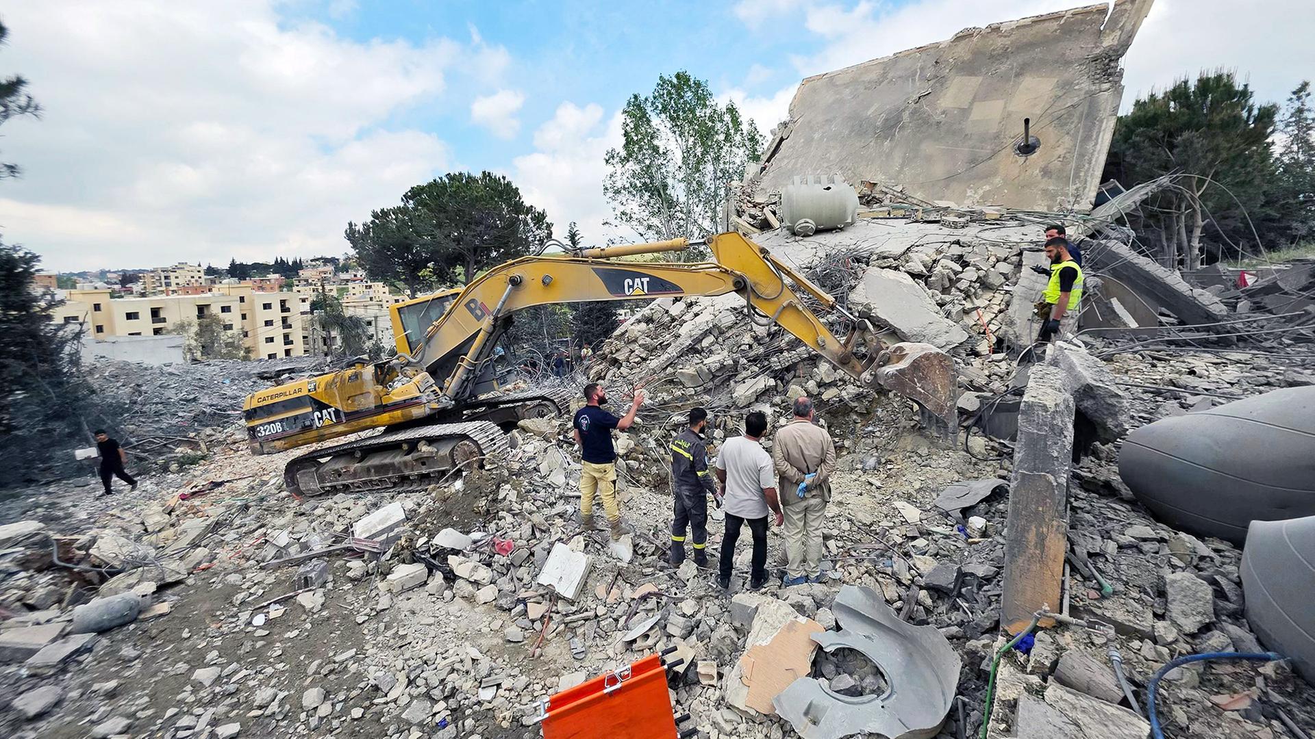 Menschen stehen in Trümmern in Nabatieh, Libanon | AFP