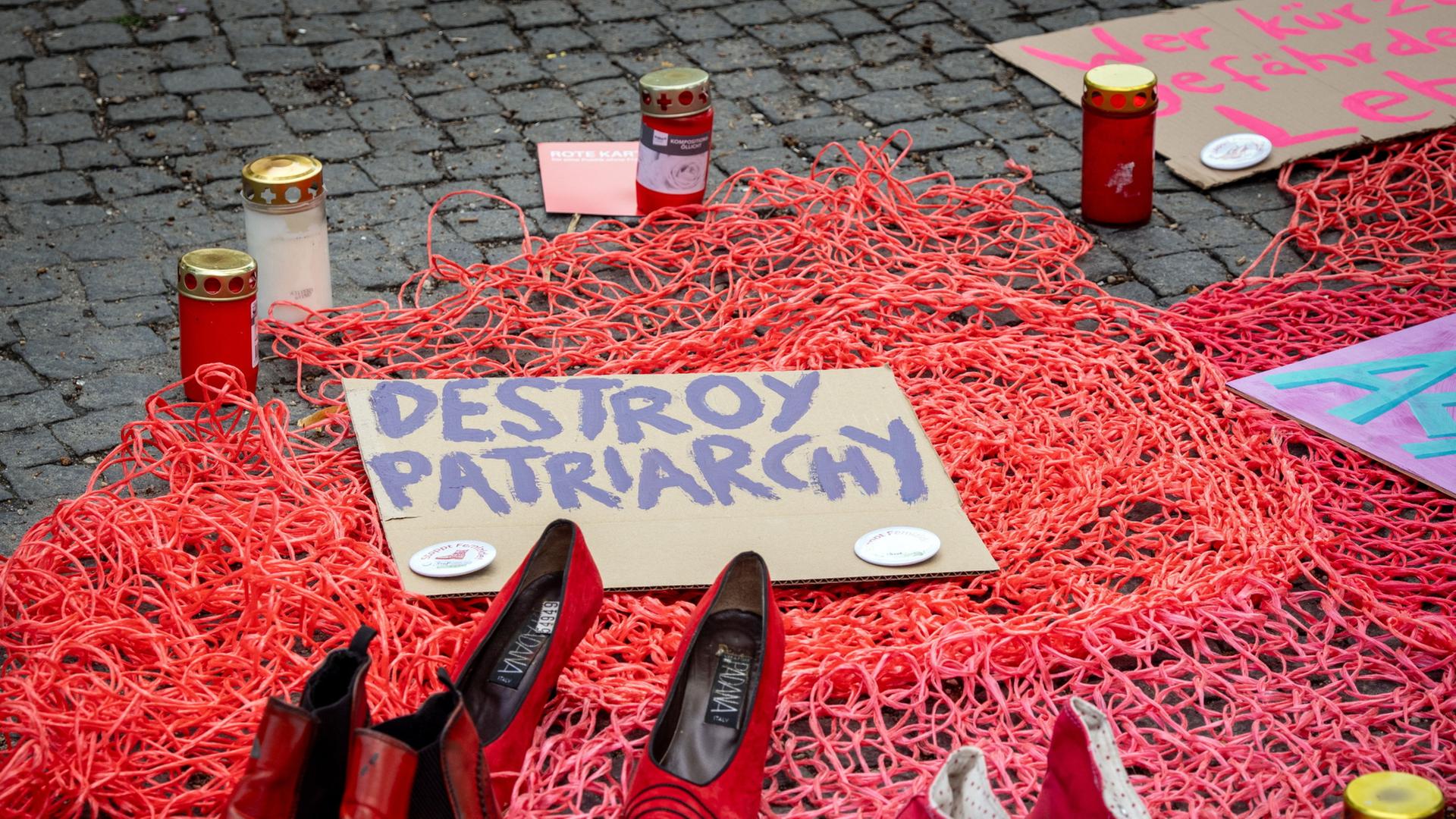 Rote Schuhe stehen paarweise wÃ¤hrend einer Kundgebung gegen Feminizide vor dem Berliner Rathaus SchÃ¶neberg neben einer Pappe mit der Aufschrift 