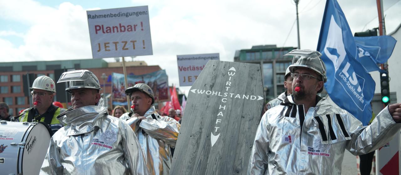 Demonstranten tragen auf einer IG-Metall-Demonstration in Berlin-Mitte einen Sarg mit der Aufschrift "Wohlstand und Wirtschaft". 