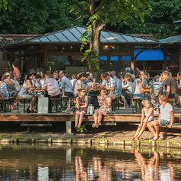 Zahlreiche Menschen sitzen in Berlin am Abend im Biergarten Neuer See im Tiergarten.