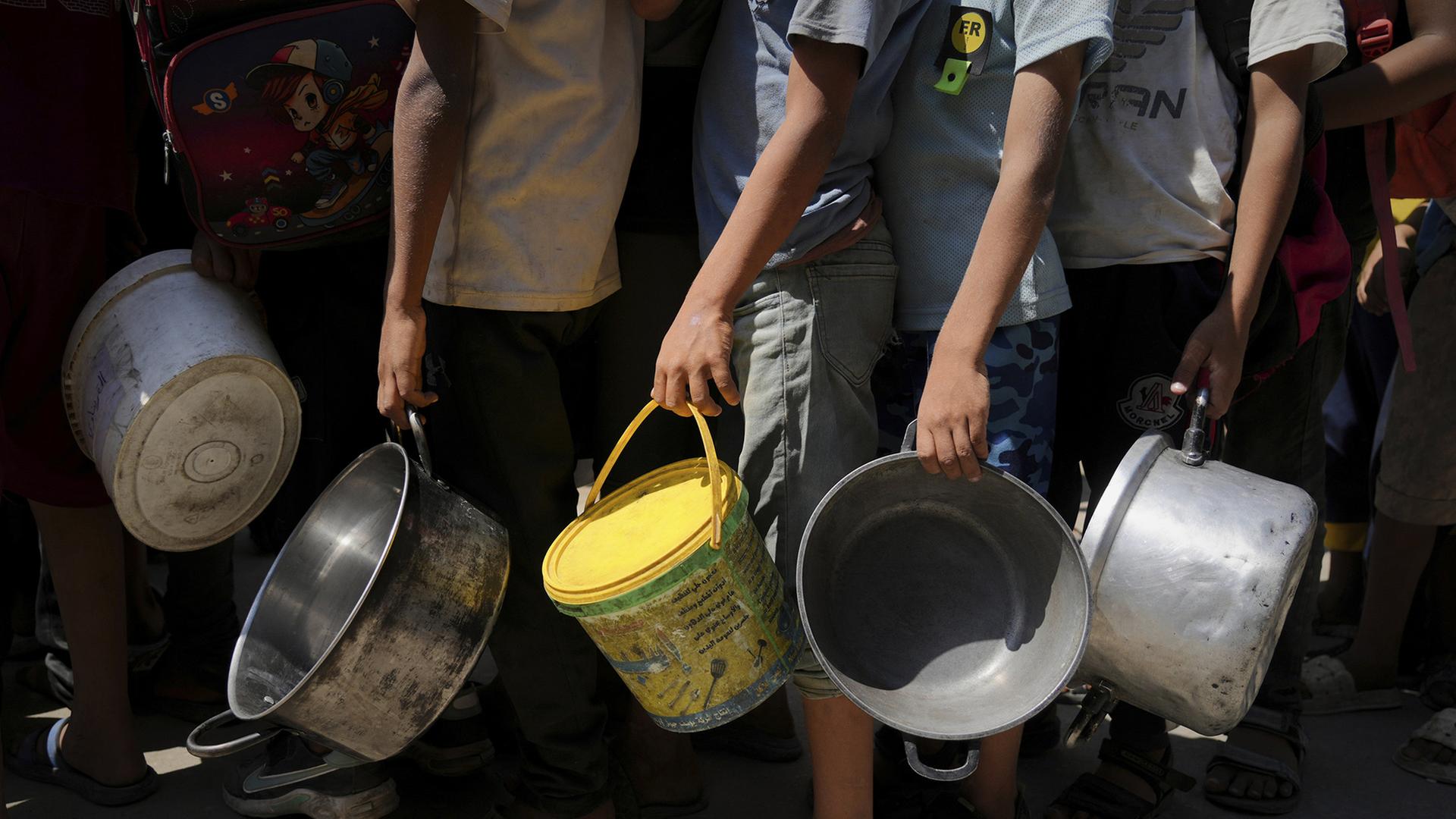 Menschen an einer warten mit Töpfen an einer Hilfsküche auf Essensspenden, Gaza | AP