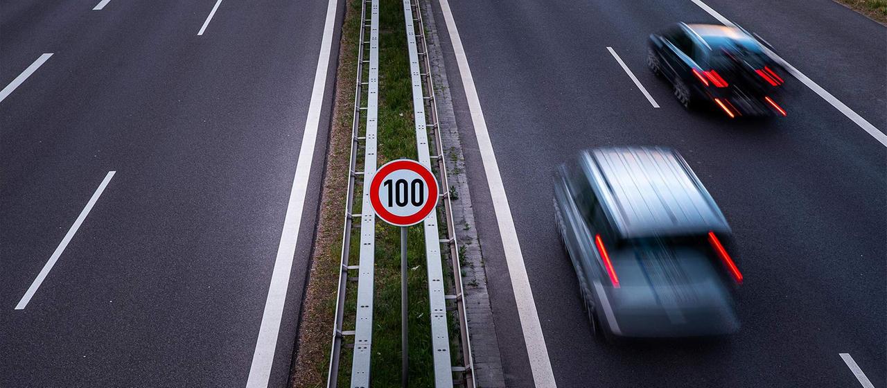 Schild an einer Autobahn zeigt die Geschwindigkeitsbegrenzung auf Tempo 100.