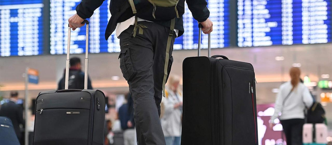 Flugreisender mit Rollkoffern.