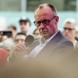 Friedrich Merz hält ein Mikrofon in den Händen.