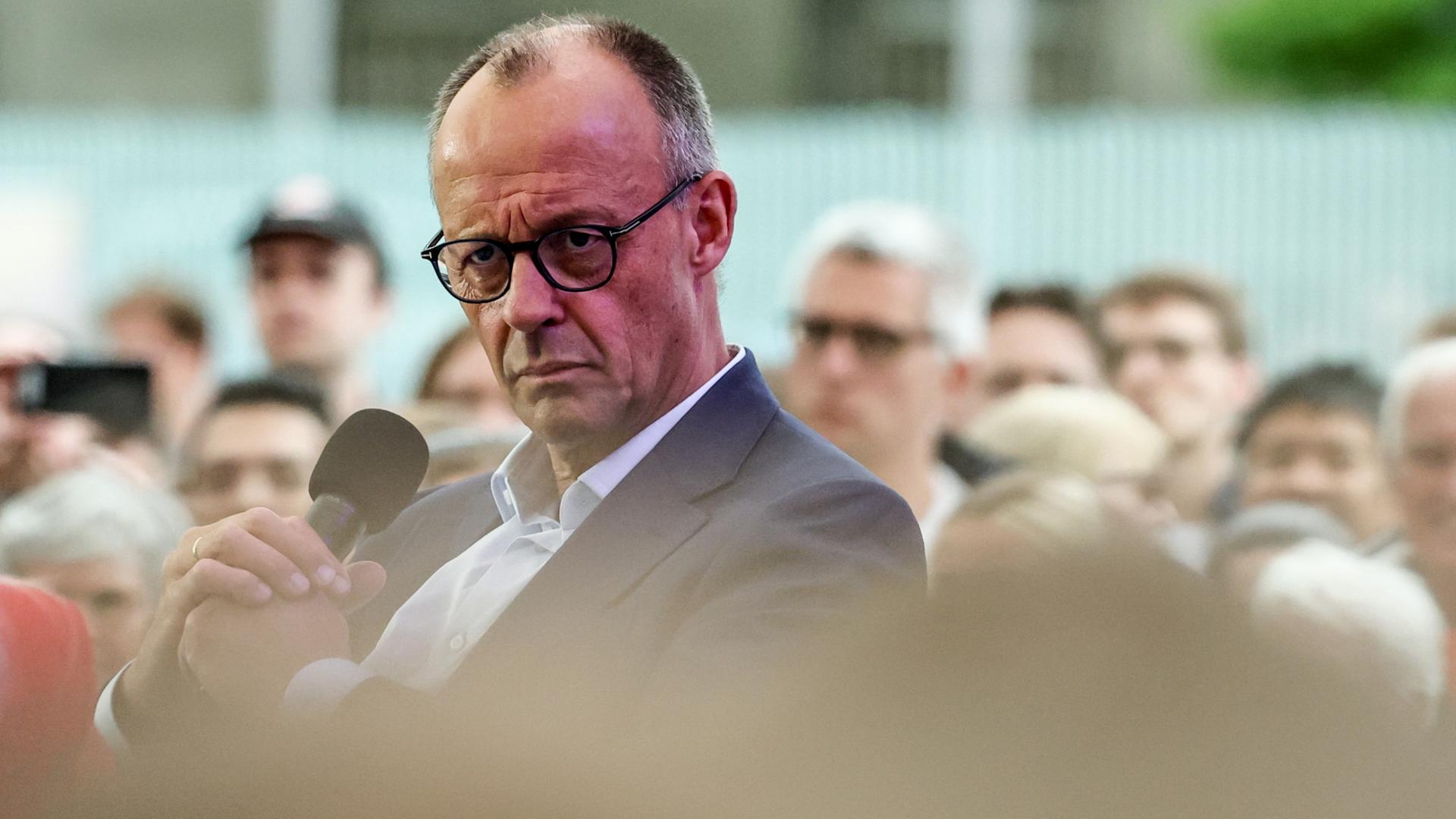 Friedrich Merz hält ein Mikrofon in den Händen. | EPA