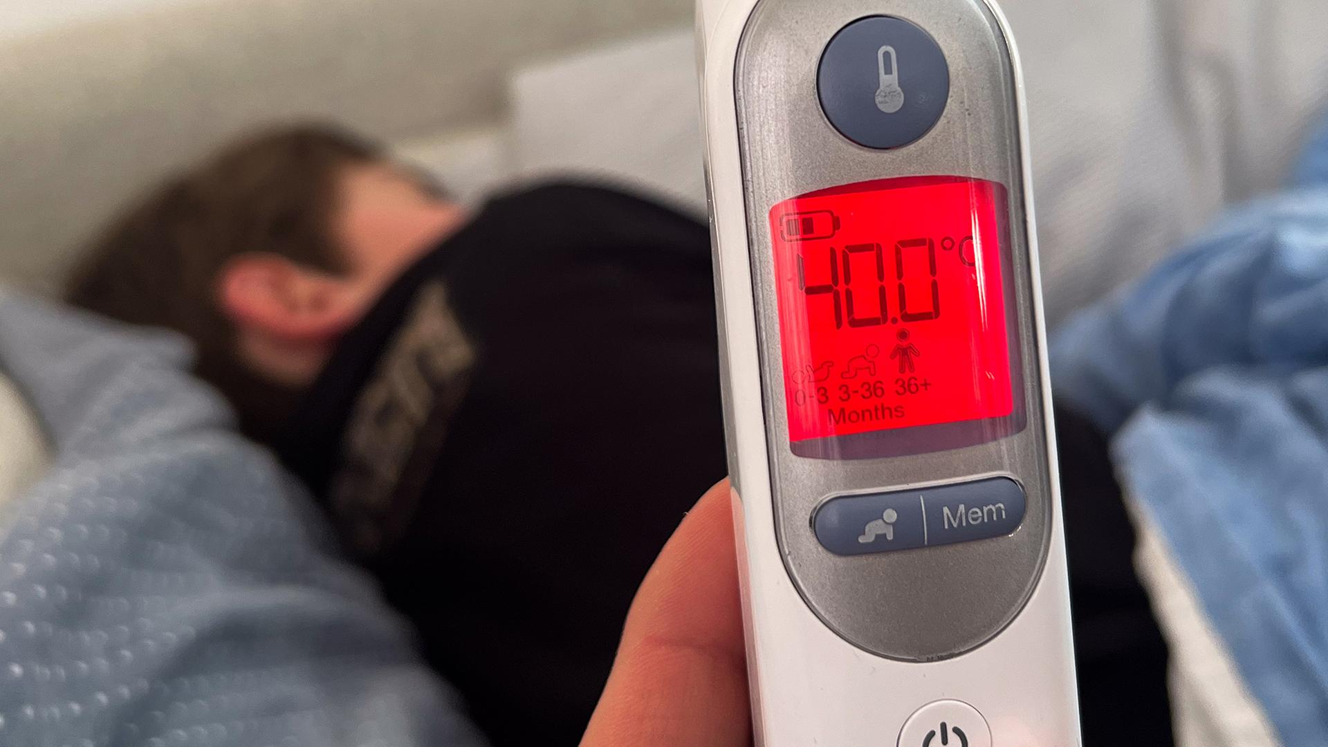 Ein Fieberthermometer zeigt eine Körpertemperatur von 40,0 Grad nach der Messung bei einem Kind an. | dpa