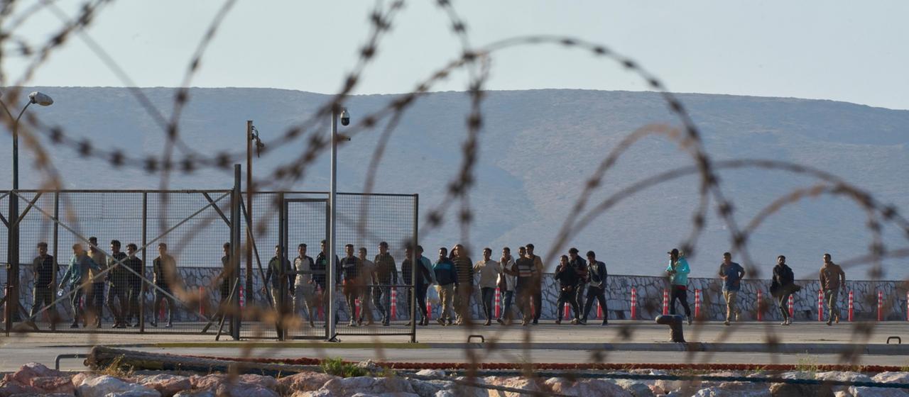 Migranten gehen nach ihrer Ankunft im Hafen von Lavrio (Griechenland).