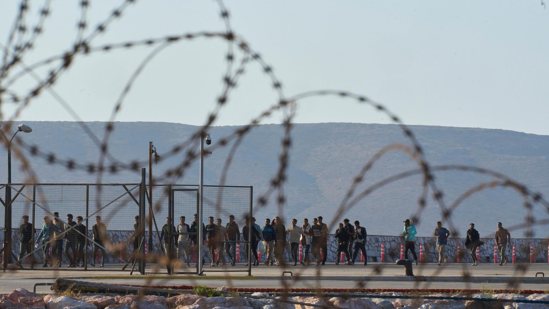 Migranten gehen nach ihrer Ankunft im Hafen von Lavrio (Griechenland). | AP Photo/Petros Giannakouris