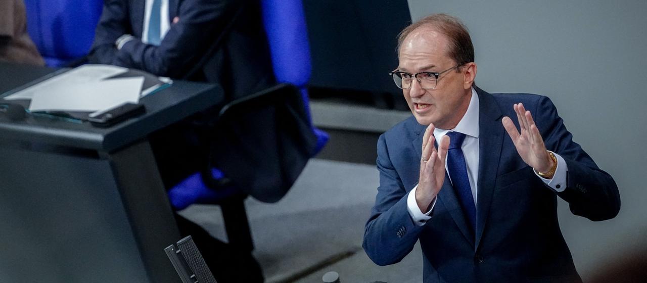Alexander Dobrindt hebt bei einer Rede im Bundetsag die Hände, im Hintergrund sitzt Friedrich Merz.