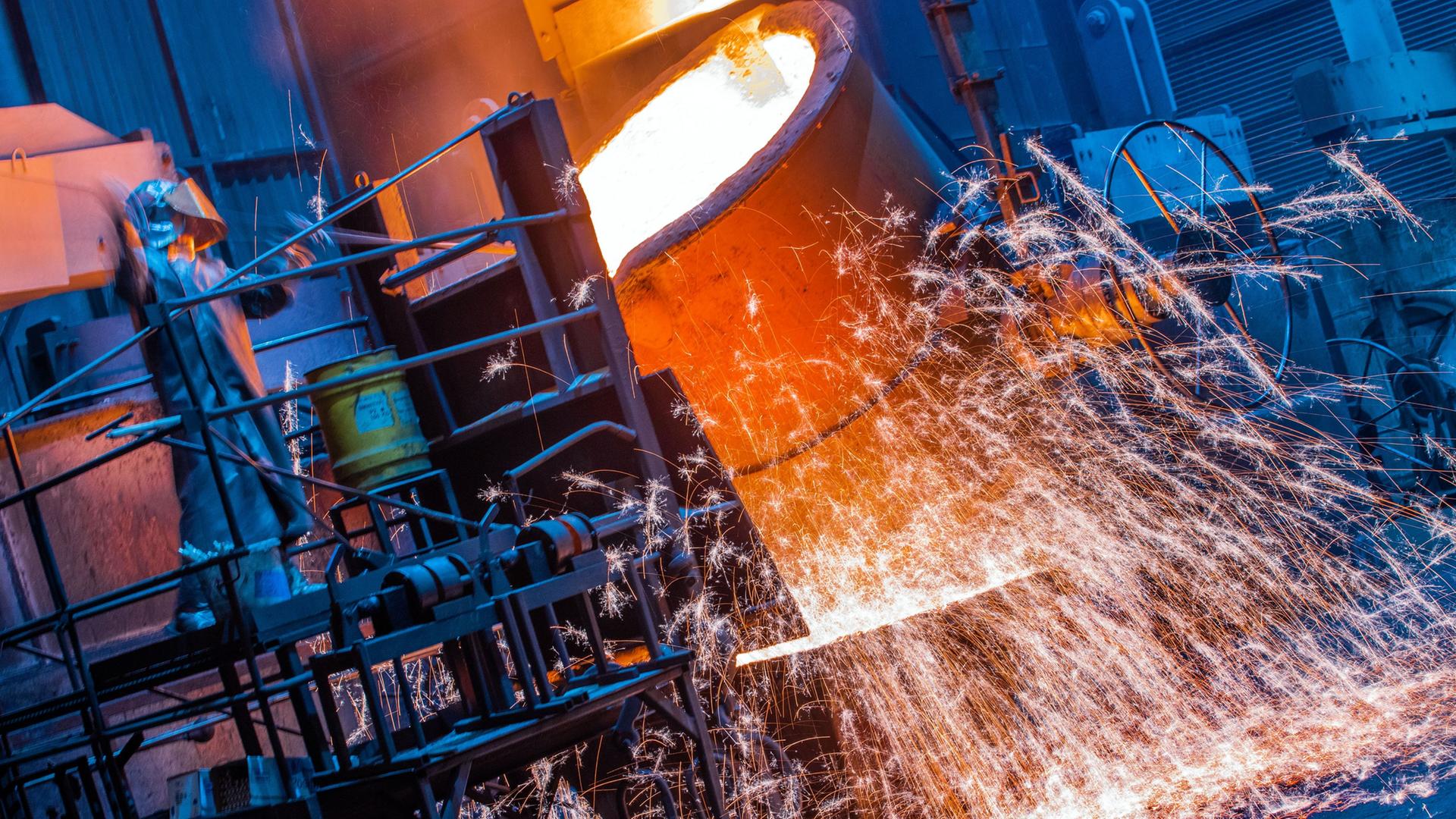 Ein Arbeiter in einem Schutzanzug arbeitet in einer Eisengießerei | dpa